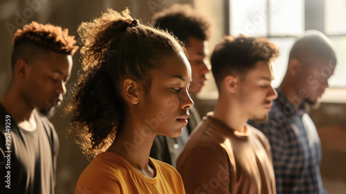 Group of diverse people, young men and women standing in church interior with their eyes closed and praying. Spiritual and religious, worship God, believe in Jesus Christ, family or friends support photo