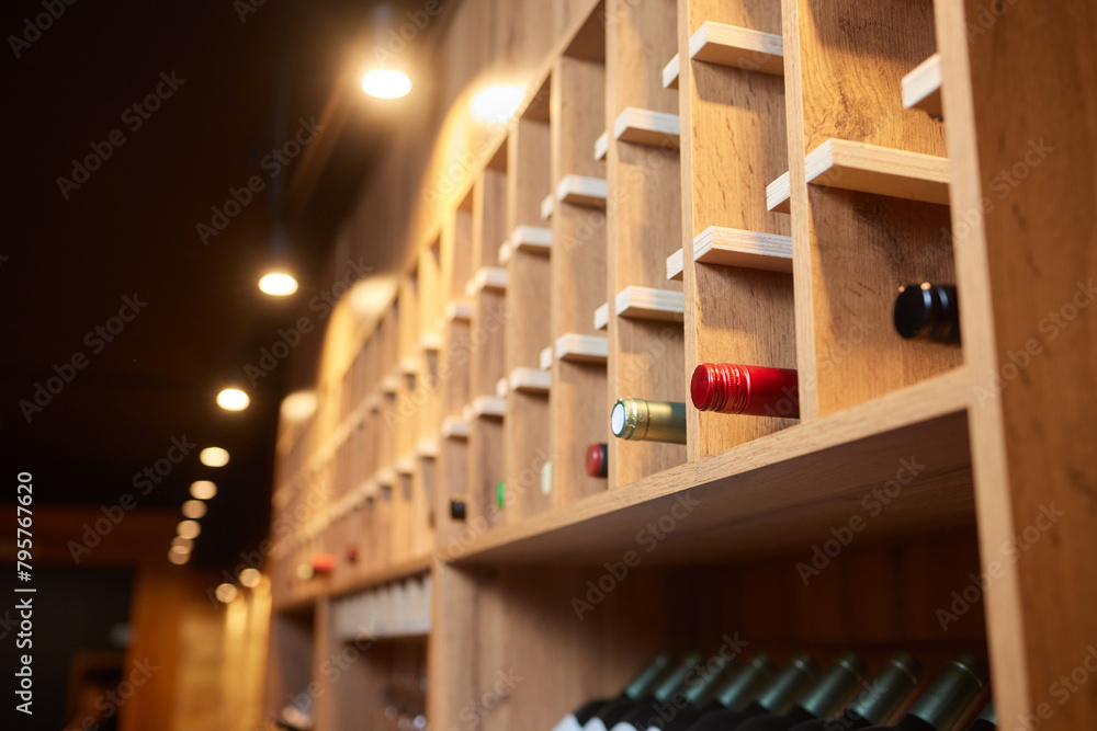 Building facade with hardwood shelving holding row of wine bottles Building facade with hardwood shelving holding row of wine bottles