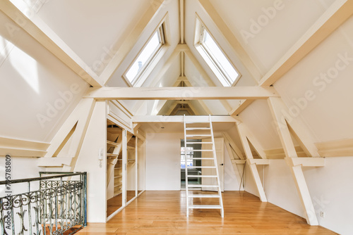Spacious attic room with skylight windows and wooden floors photo