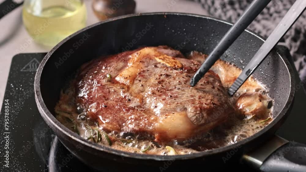 A chef cooks a beef steak on a pan in the kitchen and turns it to the other side, close-up. Process of making delicious steak. A chef cooks a beef steak on a pan in the kitchen and turns it to the other side, close-up. Process of making delicious steak.