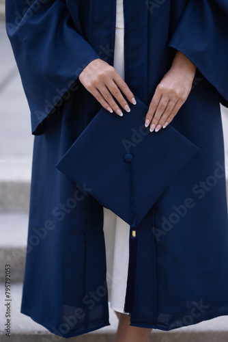 Young female hands holding navy graduation cap, verticle photo