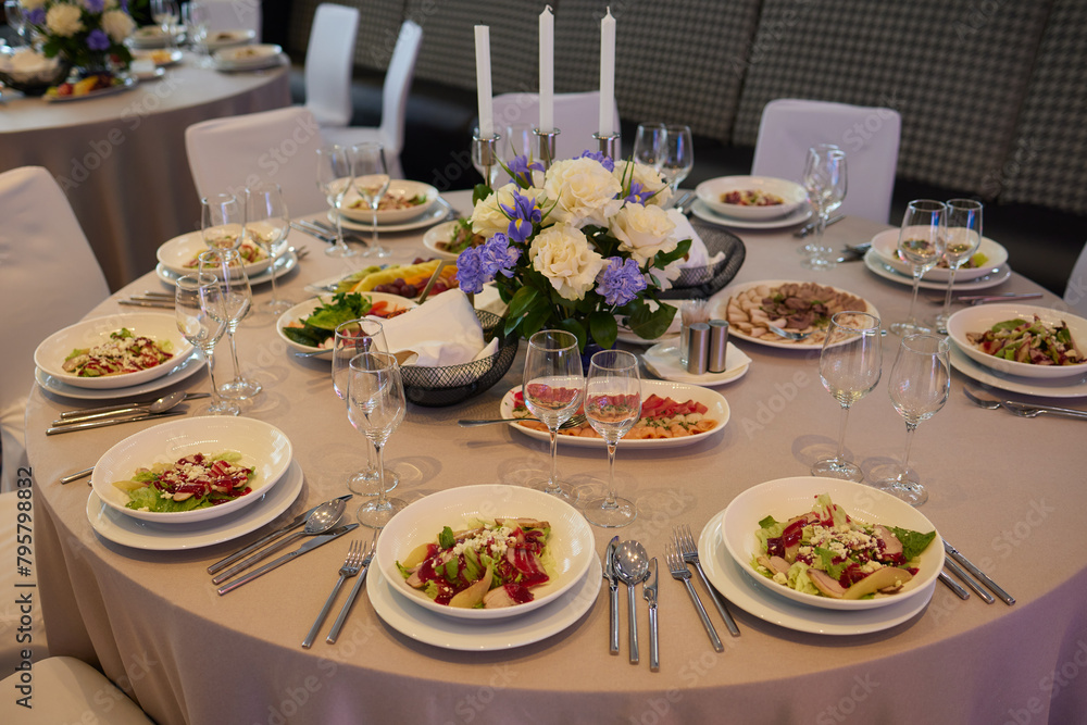 Table set with yellow tablecloth, plates of food, and wine glasses Table set with yellow tablecloth, plates of food, and wine glasses