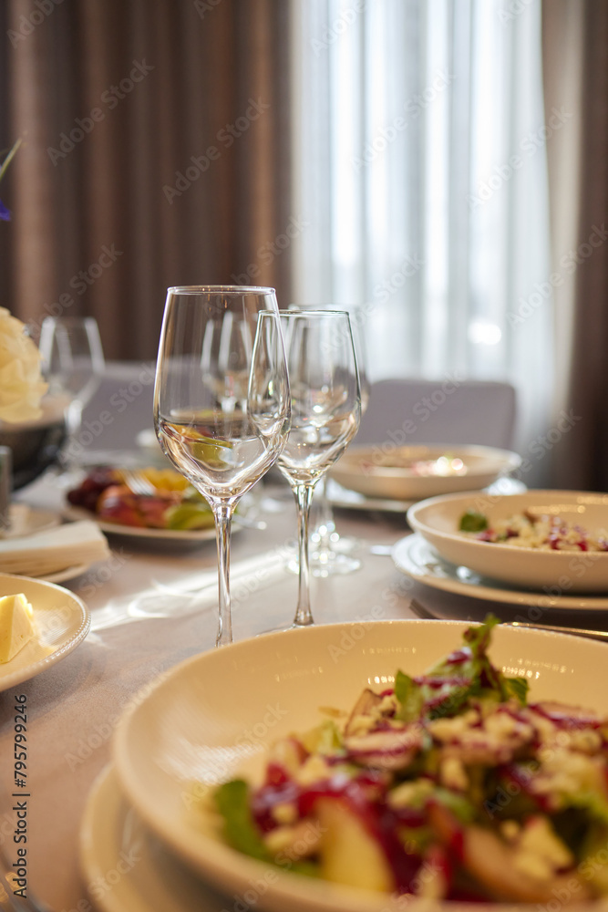 Table set with yellow tablecloth, plates of food, and wine glasses Table set with yellow tablecloth, plates of food, and wine glasses
