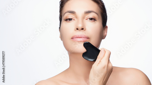 Gorgeous Middle-aged Woman Uses Gua Sha Stone for Facial Skincare Routine