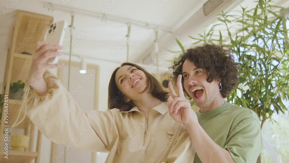 Couple in love taking a selfie in a cafe. Funny guy and girl taking selfie on smartphone in restaurant. Cute Couple Enjoy A Lunch Date