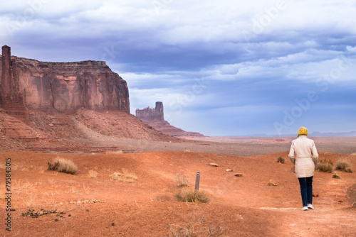 Lone hiker on Wildcat Trail, Monument Valley, with storm clouds