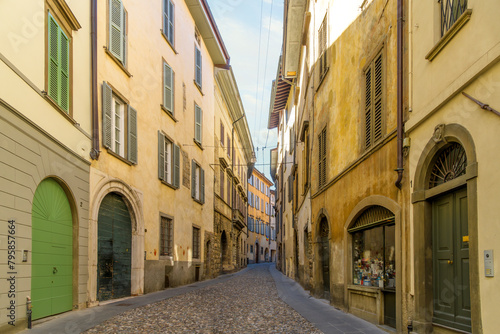 Fototapeta Naklejka Na Ścianę i Meble -  A picturesque narrow alley leading in the historic medieval old town walled Città Alta district, the historic upper district of the city of Bergamo, Italy, in the Lombardy region.	