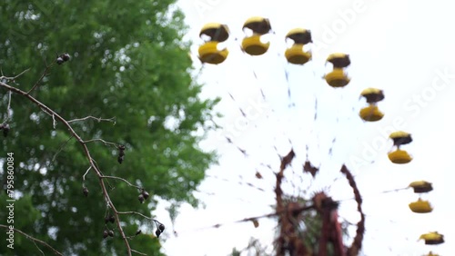 Abandoned Ferris wheel in the city of Pripyat. The whole playground was overgrown with greenery and trees. Consequences of the Chernobyl disaster.