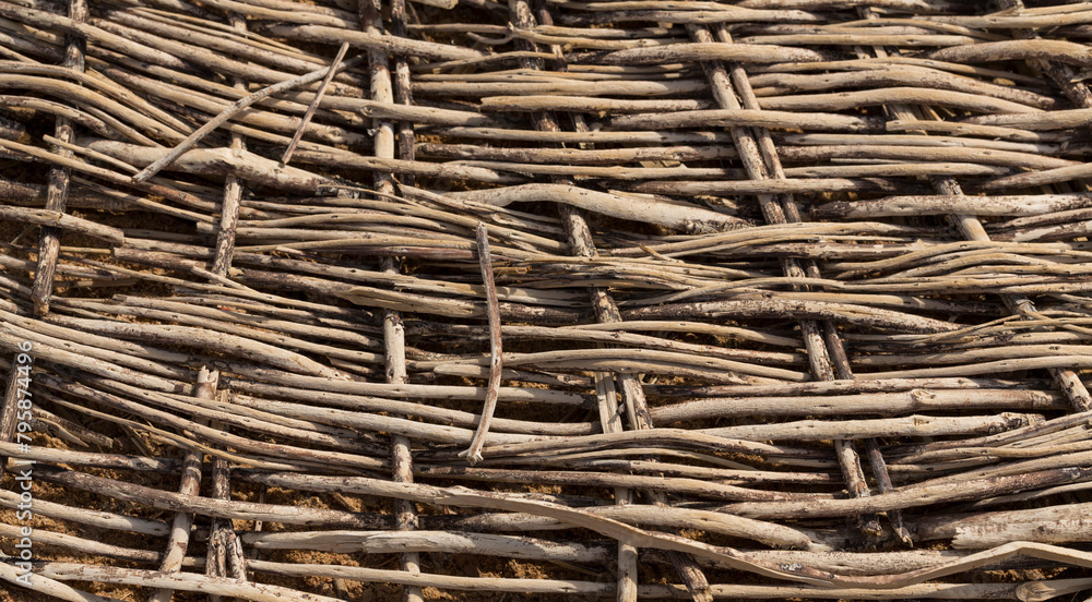 Weaving of twigs of branches. A man-made background smoldering on the ground. Weaving of twigs of branches. A man-made background smoldering on the ground.