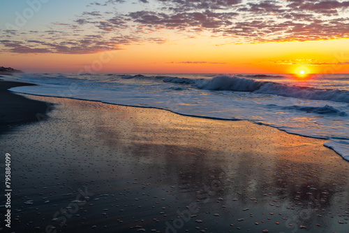 Sunrise Reflections on Smooth Beach Sand