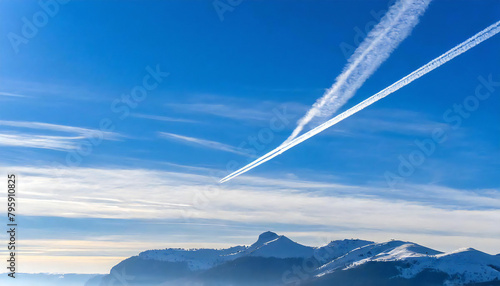 Airplanes and contrails. Blue sky background. A single contrail.