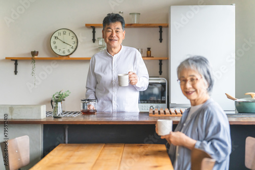 家のキッチンでコーヒーをいれる高齢者男性と高齢者女性（老夫婦） 