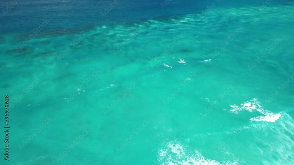 Aerial view of the Great Barrier Reef near Punta Cana, Dominican Republic, showing colorful coral and turquoise ocean blending with the bright Atlantic Ocean glow, forming a beautiful blue gradient. Aerial view of the Great Barrier Reef near Punta Cana, Dominican Republic, showing colorful coral and turquoise ocean blending with the bright Atlantic Ocean glow, forming a beautiful blue gradient.