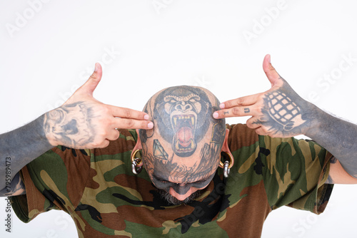 A man showing off a gorilla tattoo on his shaved scalp. Bowing down extensively covered with tats and body piercings. Example of head tattoos. Isolated on a white background. photo