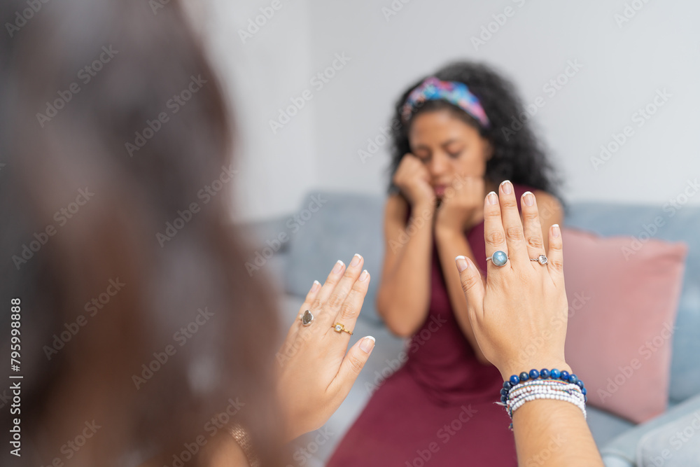 Psychologist gesturing with hands to calm down a sad patient Psychologist gesturing with hands to calm down a sad patient
