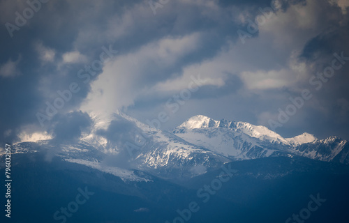 Snowy mountain range with blue sky and clouds. Retezat Mountain in The Carpathians. photo