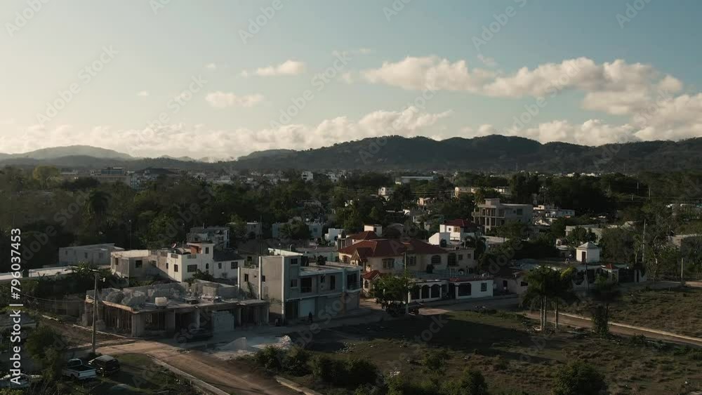 Aerial drone view of small Dominican neighborhood with mountain range at sunset Aerial drone view of small Dominican neighborhood with mountain range at sunset