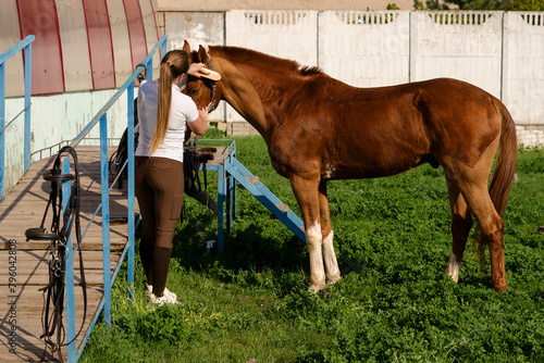 Woman brushing horse at barn entrance