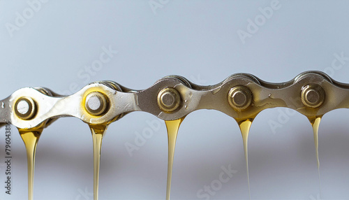 Chain lubrication with oil. Lubricant oil dripping from machine chain photo