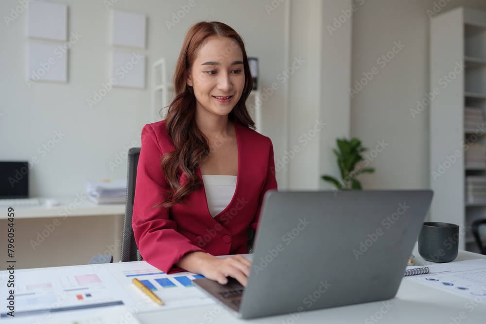 Asian businesswoman, self-employed working on laptop computer typing e-commerce marketing financial report on real estate project in office management concept. Asian businesswoman, self-employed working on laptop computer typing e-commerce marketing financial report on real estate project in office management concept.