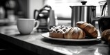 A plate of croissants and a cup of coffee sit on a counter. The scene is cozy and inviting, perfect for a morning breakfast