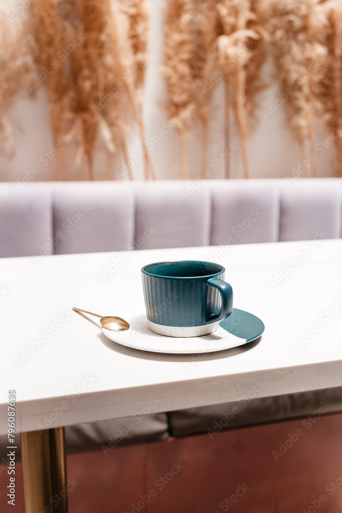 A cup of hot coffee on a white table on a light background. Hot drinks concept