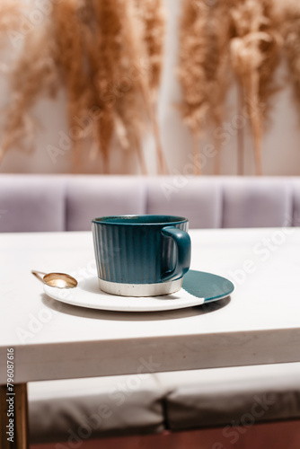 Fototapeta Naklejka Na Ścianę i Meble -  Ceramic cup of hot Americano on white table. Concept of hot drinks on light background with dried flowers