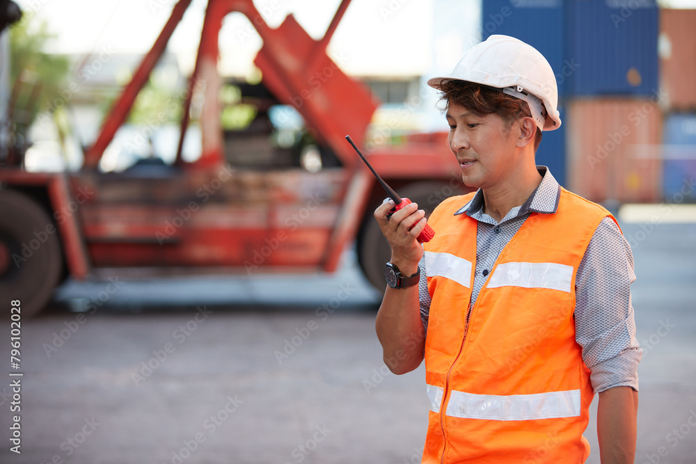 factory worker or engineer using walkie talkie and talking about work in containers warehouse storage factory worker or engineer using walkie talkie and talking about work in containers warehouse storage