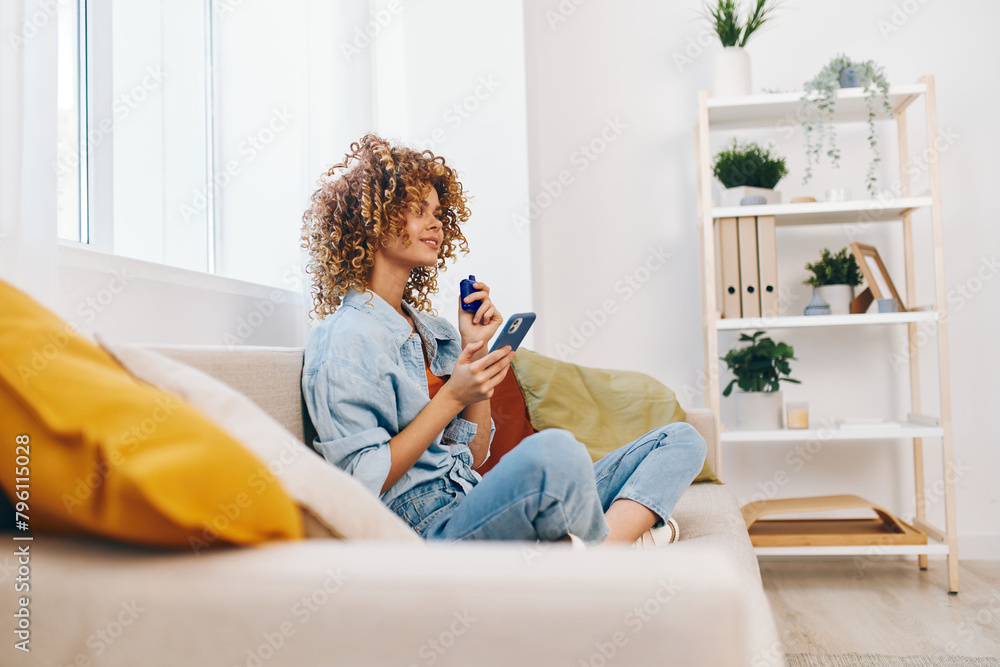 Cozy Couch, Happy Woman Holding Smartphone, Relaxing at Home Cozy Couch, Happy Woman Holding Smartphone, Relaxing at Home