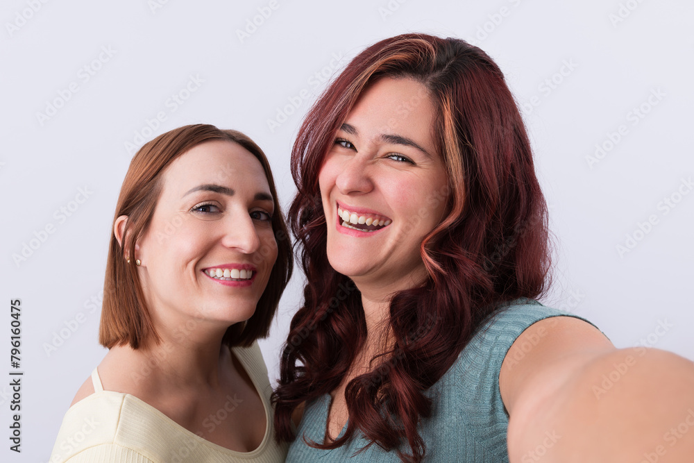 2 Young women laughing and looking at camera while taking a selfie. Friendship concept 2 Young women laughing and looking at camera while taking a selfie. Friendship concept