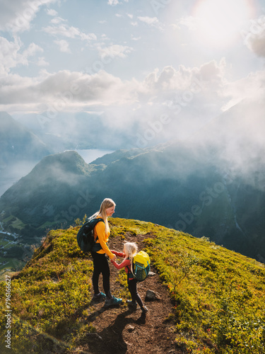 Mother and child with backpack hiking in mountains together summer family vacations in Norway active healthy lifestyle outdoor adventure eco tourism, woman mom with daughter enjoying view