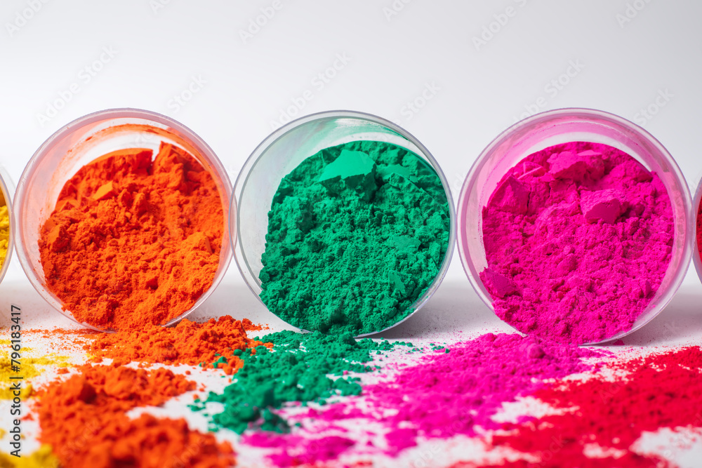 Colorful holi powder in a plastic containers on white background. Colorful holi powder in a plastic containers on white background.