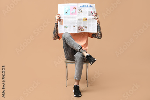 Man with newspaper on beige...