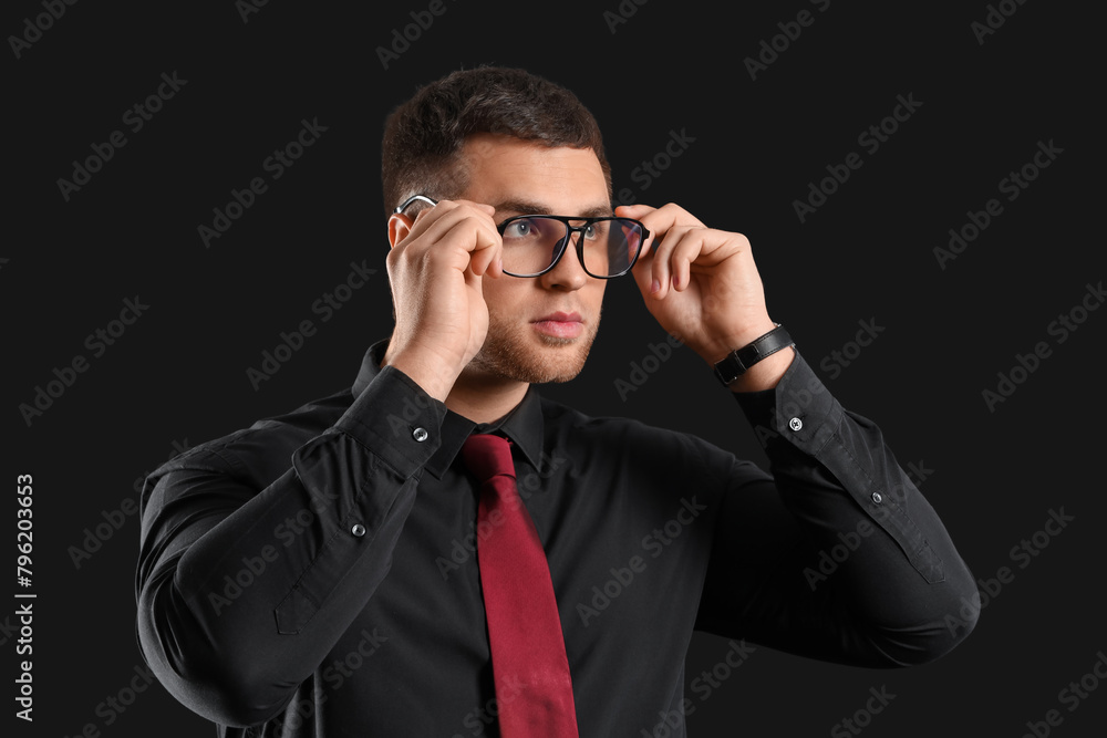 Handsome businessman in eyeglasses on black background Handsome businessman in eyeglasses on black background