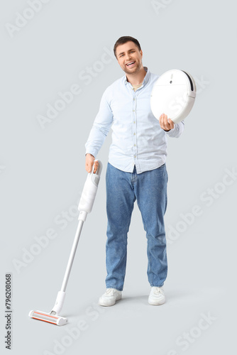 Handsome man with vacuum cl...