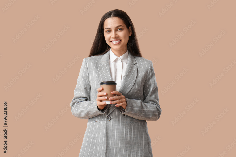 Pretty businesswoman with cup of coffee on beige background Pretty businesswoman with cup of coffee on beige background