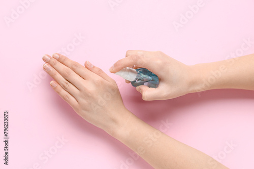 Woman applying sanitizer on...