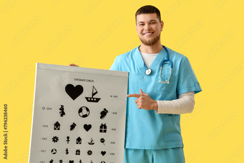 Male ophthalmologist pointing at eye test chart on yellow background Male ophthalmologist pointing at eye test chart on yellow background