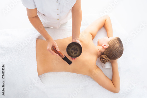 Young woman getting massaging treatment over white. Spa, healthcare and recreation concept.