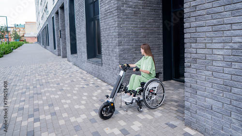Slika na platnu A woman in a wheelchair with an assistive device for manual control