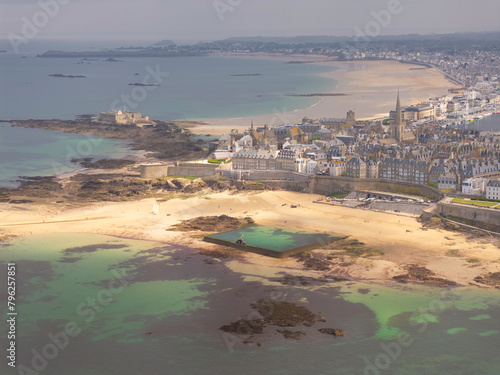 Vue aerienne d'une cité historique de France sur le littoral de la Manche, vue drone de la cité corsaire de saint malo en Bretagne avec la plage et la piscine de Bon Secours à marée basse
