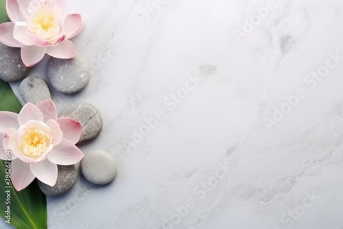 Smooth stones, fresh flowers, and green leaves on a white marble background. Copy space, spa concept