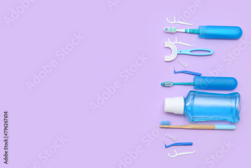 Toothbrushes with floss toothpicks and mouthwash on lilac background