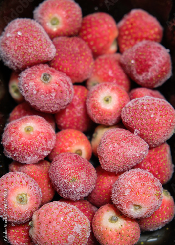 Close up photo of frozen fruits. Frozen strawberries background. Frozen strawberry with crystal of ice.