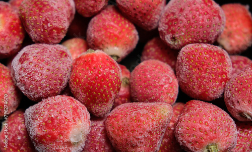 Close up photo of frozen fruits. Frozen strawberries background. Frozen strawberry with crystal of ice.