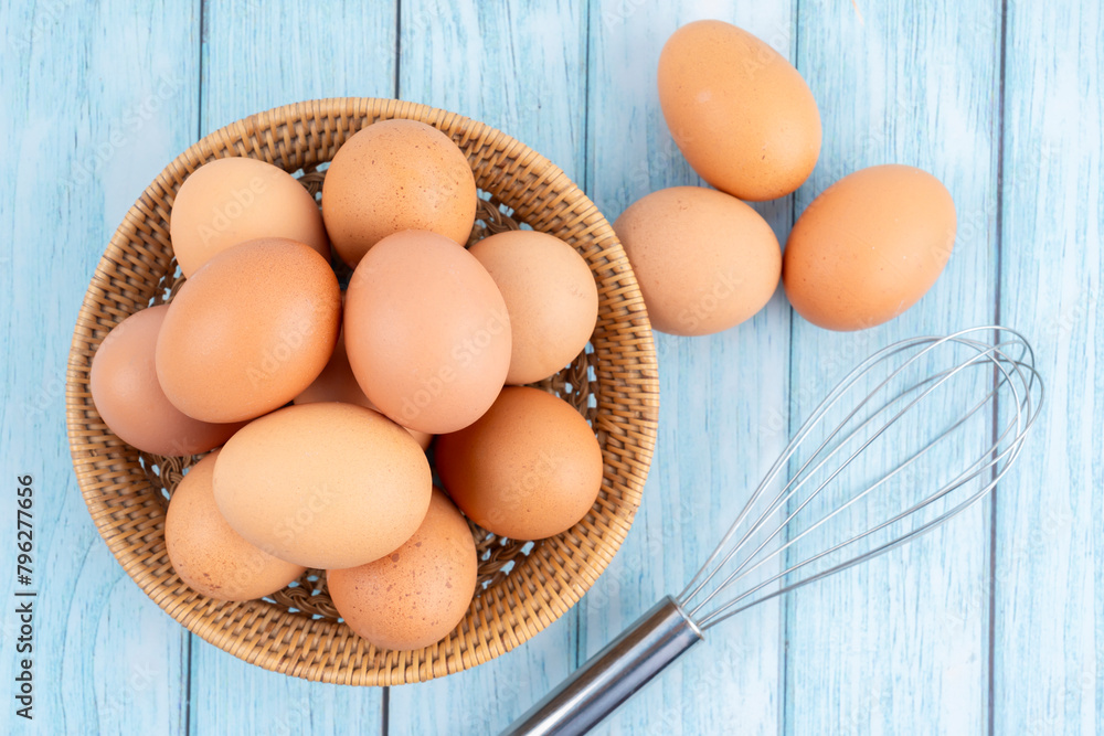 Brown eggs in a wooden weave basket on wooden floor. Brown eggs in a wooden weave basket on wooden floor.