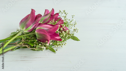 Bouquet of pink and green tulips and branches with white flowers on a white background