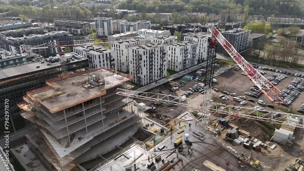 Aerial Flight Over a New Constructions Development Site in Vilnius, Lithuania. Urban Construction Site, Aerial View. High crane works on building site. Crane and building construction site. Aerial Flight Over a New Constructions Development Site in Vilnius, Lithuania. Urban Construction Site, Aerial View. High crane works on building site. Crane and building construction site.