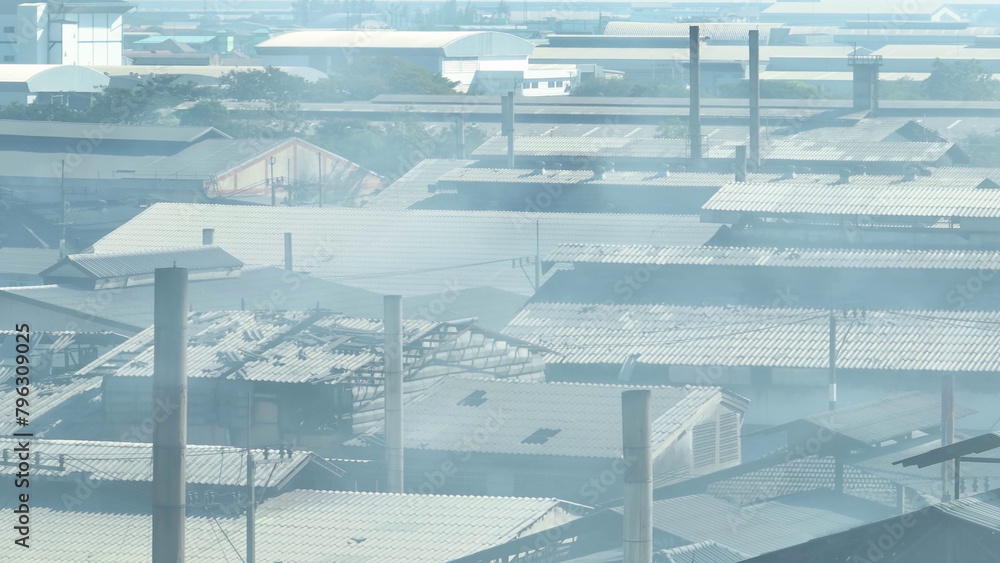 Obraz premium The drone's view exposes industrial estates emitting smoke, prompting us to address their environmental footprint for a cleaner future. Respiratory illnesses and Industrial emissions concept. 