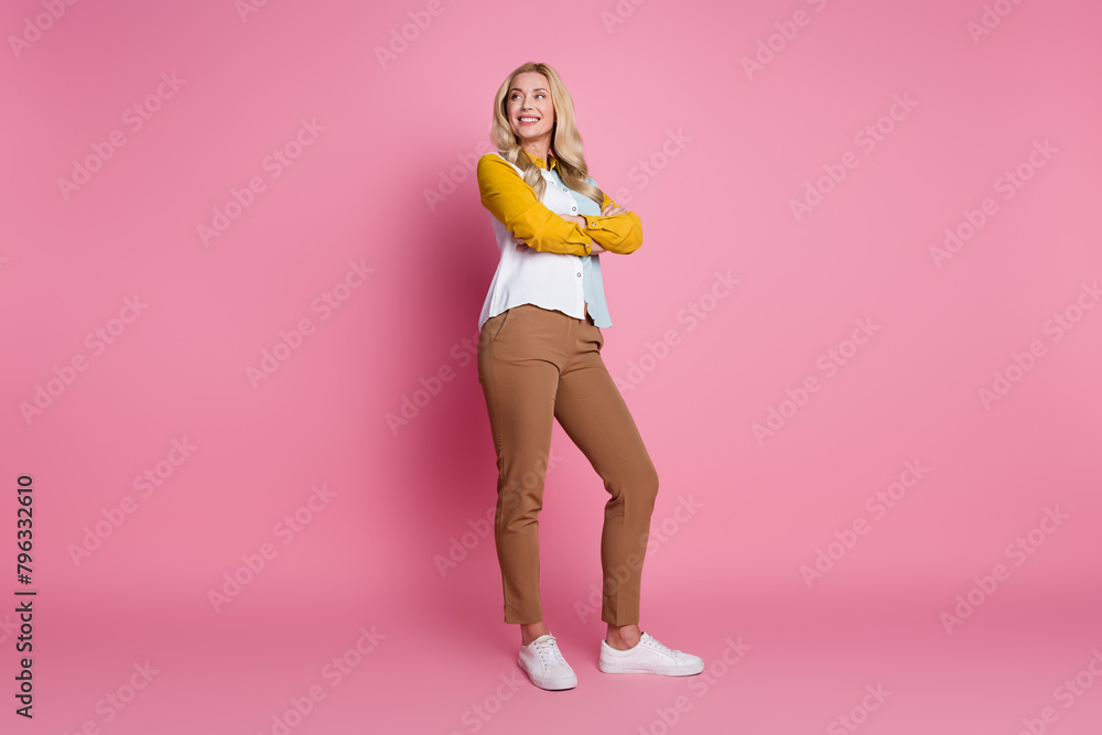 Photo of successful lovely woman wear trendy clothes standing crossed arms looking empty space isolated on pink color background Photo of successful lovely woman wear trendy clothes standing crossed arms looking empty space isolated on pink color background
